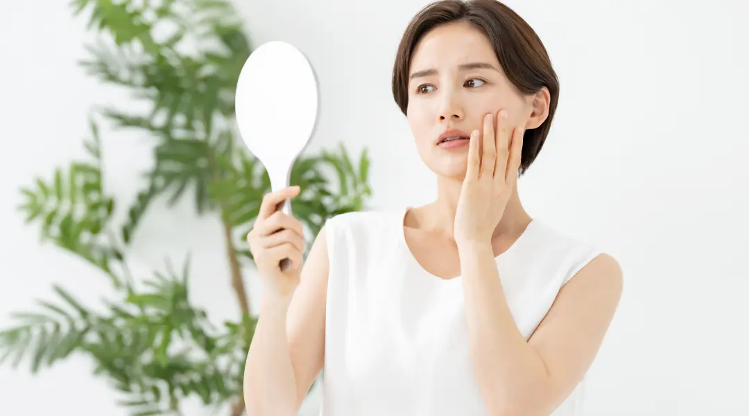 鏡を見て考えている女性